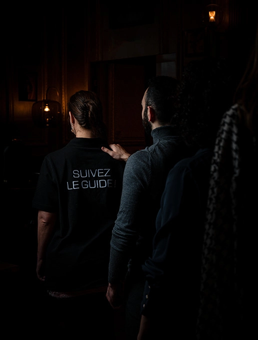 Des invités marchent en file pour assister à une célébration d'anniversaire immersive à Dans le Noir ?