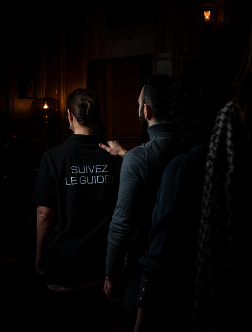 Des invités marchent en file pour assister à une célébration d'anniversaire immersive à Dans le Noir ?