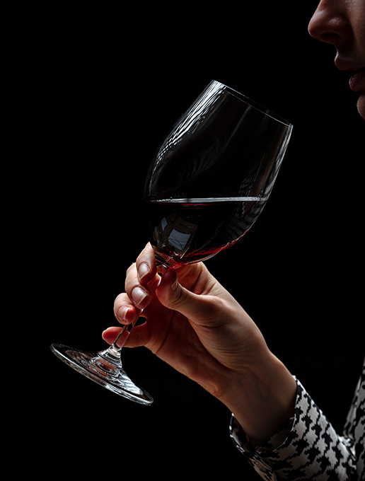 Une jeune femme savourant un verre de vin dans une ambiance cosy pour célébrer Noël au restaurant Dans le Noir ?